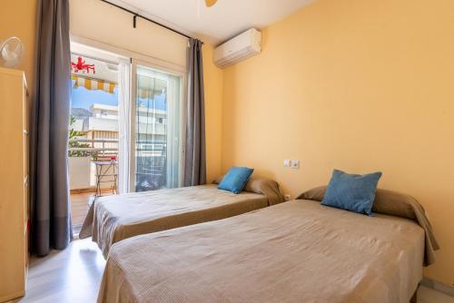 Dos camas en una habitación con balcón. en Apartamento Torremolinos Lc, en Torremolinos