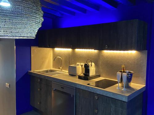 kuchnia ze zlewem i niebieskim oświetleniem w obiekcie Private Room & Spa avec jacuzzi privatif w Lille