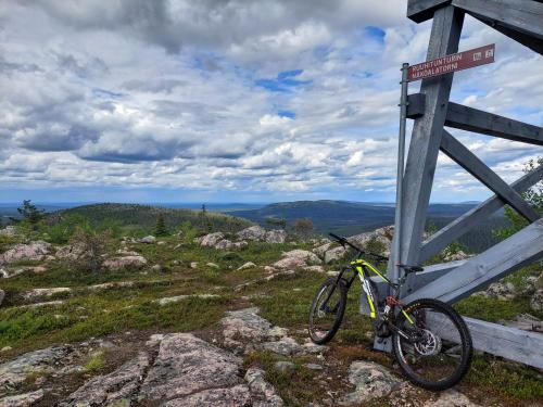 a bike parked next to a sign on a mountain at Isokelo Log Apartments in Salla