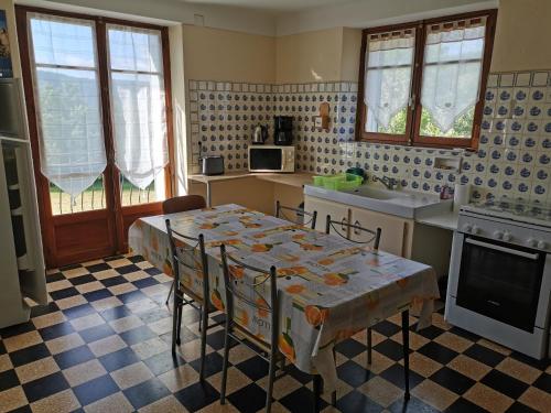 - une cuisine avec une table, des chaises et un évier dans l'établissement Gite CLEVACANCES, à Laval-du-Tarn