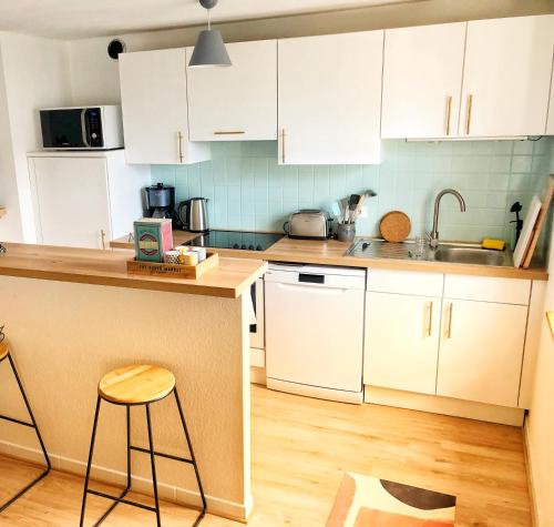 a kitchen with white cabinets and a counter top at Charming apartment Basel border - 3 bedrooms in Hégenheim