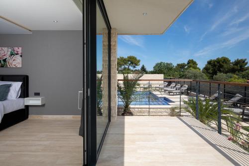 a bedroom with a balcony with a view of a pool at Boutique Apartments Kristo in Medulin