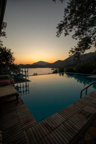 a view of a swimming pool with the sunset in the background at Beyaz Yunus Hotel - Adult Only in Oludeniz
