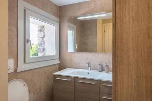 ein Bad mit einem Waschbecken und einem Spiegel in der Unterkunft Villa privata con piscina Colonno in Colonno