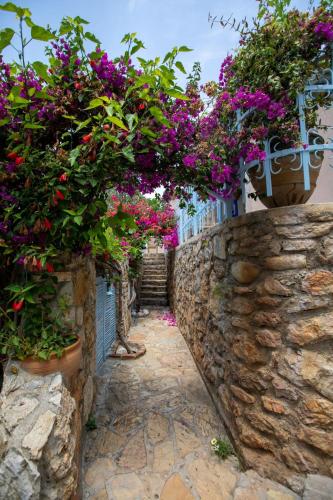 a stone path with flowers on a stone wall at Beyaz Yunus Hotel - Adult Only in Oludeniz
