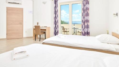 sypialnia z 2 łóżkami i stołem z widokiem w obiekcie Villa Melli by Villas Holiday w mieście Vižinada