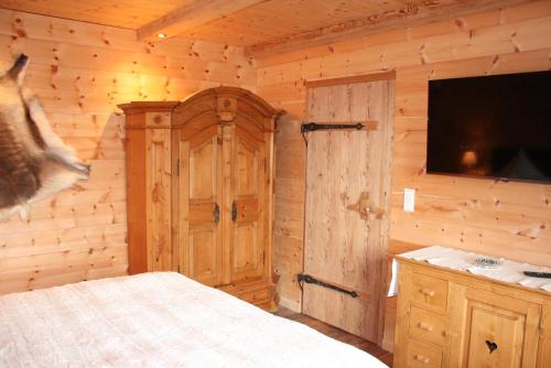 a bedroom with a bed and a flat screen tv at Alpensuite Wellness in Inzell