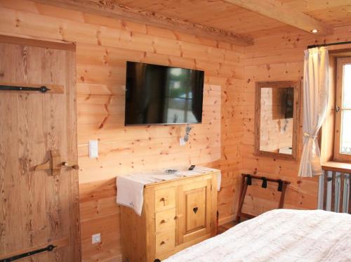 ein Schlafzimmer mit einem TV an einer Holzwand in der Unterkunft Alpensuite Wellness in Inzell