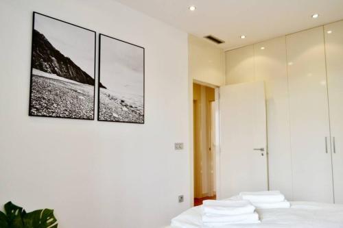 1 dormitorio con 1 cama con 3 cuadros en la pared en Hola Valencia - Holiday Apartments, en Valencia