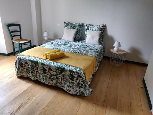 1 dormitorio con 1 cama y suelo de madera en Le Logis de Lou, en Blars