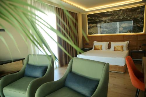 pokój hotelowy z łóżkiem i 2 krzesłami w obiekcie Kraal Hotel Vlore we Wlorze