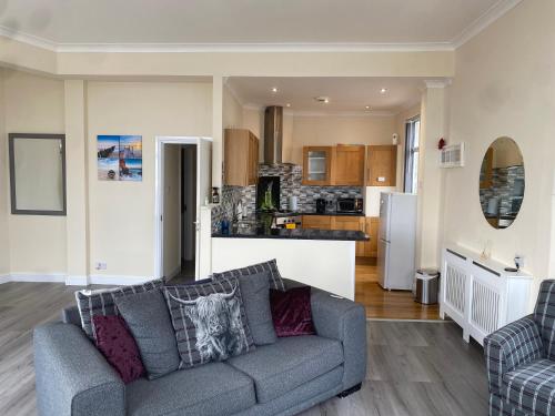 a living room with a couch and a kitchen at Redcar Seaview Apartments in Redcar