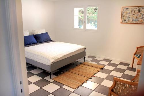 ein Schlafzimmer mit einem Bett und einem karierten Boden in der Unterkunft VILLA ARVOR CANNES Appartement indépendant en bas de maison in Cannes