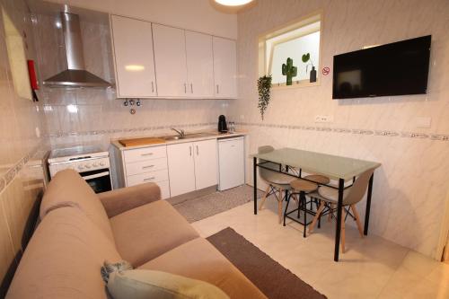 a living room with a couch and a table in a kitchen at Apartamento nas Olaias a 5 minutos da Faculdade ISEL e IST in Lisbon