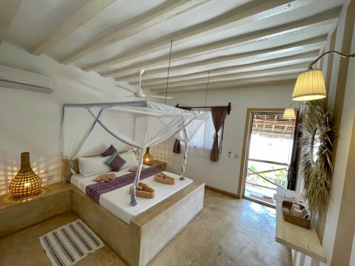 a bedroom with a bed with a canopy at Villa Huruma in Paje