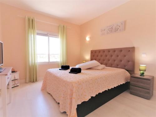 a bedroom with a large bed and a television at Summer Beach Apartment litoralmar in Portimão