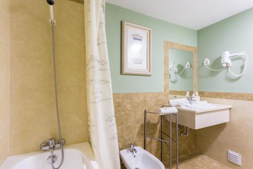 ein Badezimmer mit zwei Waschbecken, einer Badewanne und einer Dusche in der Unterkunft Summer Beach Apartment litoralmar in Portimão