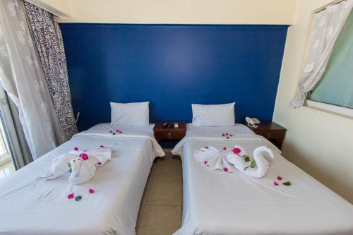 two beds in a room with swans on them at Philae Hotel Aswan in Aswan