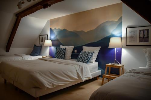 une chambre avec deux lits et un tableau au mur dans l'établissement Le Scenario, à Carentan