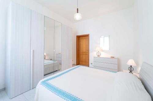 una camera bianca con un grande letto e un bagno di Onda Blu ad Alghero