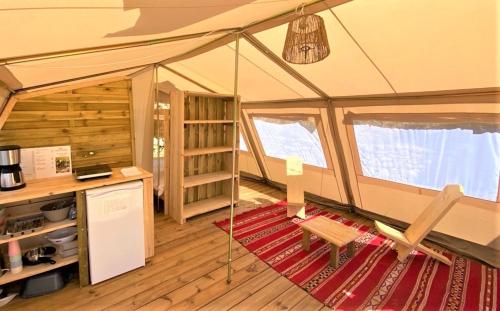 an interior view of a tent with a red rug at LES BASTIDES DE CHANTERAINE Bungalows, Lodges & Spa in Aiguines