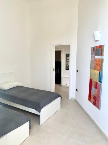 a bedroom with two beds and a painting on the wall at Luxury apartment Vitruvio in Formia