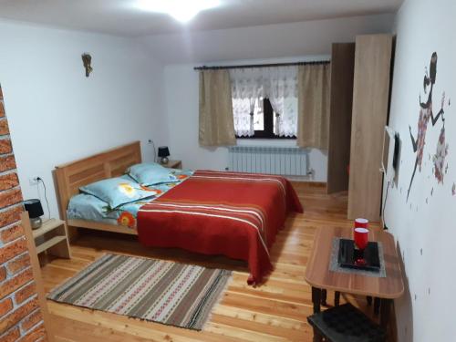 a bedroom with a bed and a table in it at CASA DINTRE PINI in Păltinoasa
