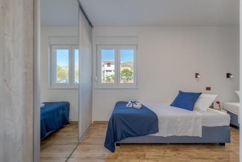 una camera da letto bianca con un letto e uno specchio di Nevera Apartment a Trogir