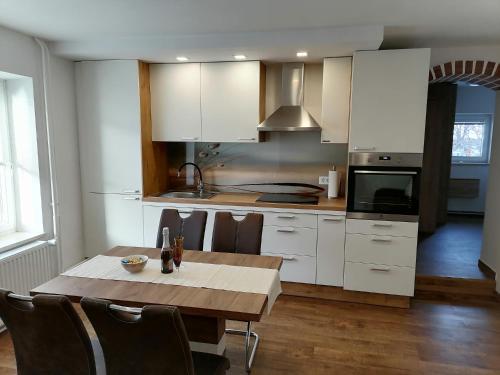 a kitchen with a wooden table and white cabinets at Žbogar in Rateče