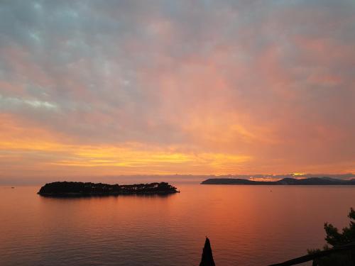 eine Insel mitten im Wasser bei Sonnenuntergang in der Unterkunft Apartments Lovro in Dubrovnik