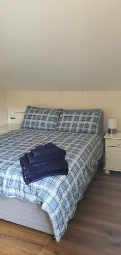Una cama con una camisa azul encima. en Hydeaway 2, en Donegal