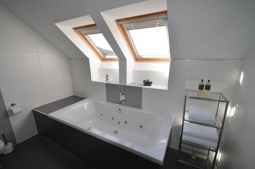 y baño con bañera grande y ventana. en Lochview Guesthouse en Corran