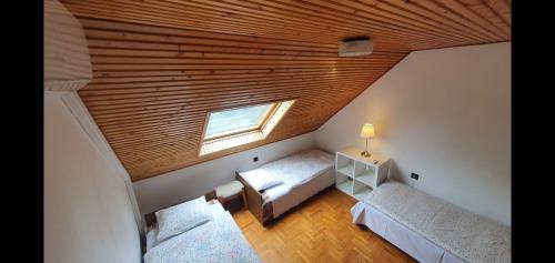 a attic room with two beds and a wooden ceiling at Gold Apartman in Zamárdi