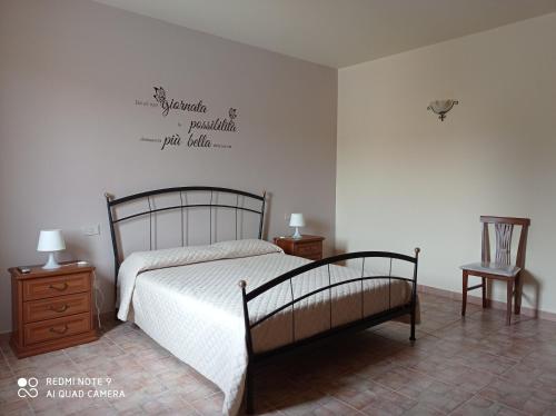 a bedroom with a bed and two night stands and a table at Agriturismo Mandriagiumenta in Caltavuturo