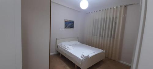 ein kleines Schlafzimmer mit einem weißen Bett in einem Zimmer in der Unterkunft Odri Apartment in Vlorë
