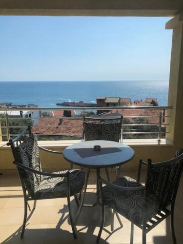 a patio with a table and two chairs on a balcony at BMV room with east island view in Sveti Stefan