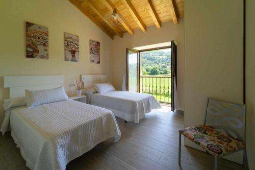 a bedroom with two beds and a large window at Complejo Rural El Cerradón in Alceda