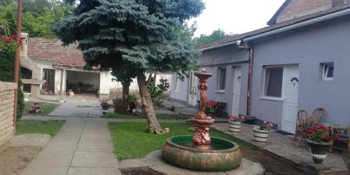 a fountain in the yard of a house with a tree at SOBE ŠPONGA in Kikinda