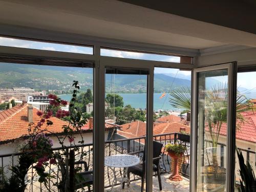a room with a balcony with a view of the water at Villa Stefanija in Ohrid