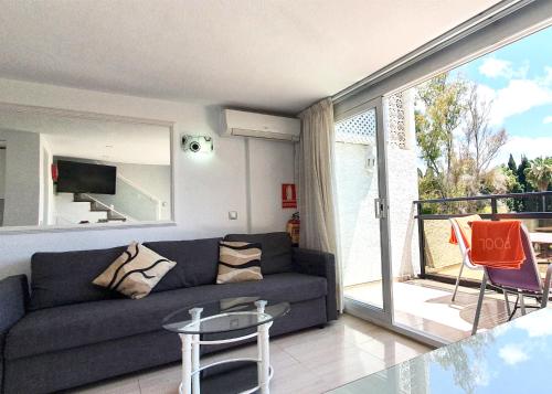 sala de estar con sofá y balcón en Skol 216 1Bedroom Duplex First Line Beach, en Marbella