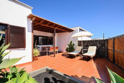 a patio with an umbrella and chairs and a table at Casa Gasparini in Tahiche
