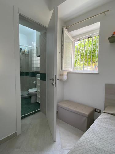 a white bathroom with a toilet and a window at Momenti e Monumenti in Palermo