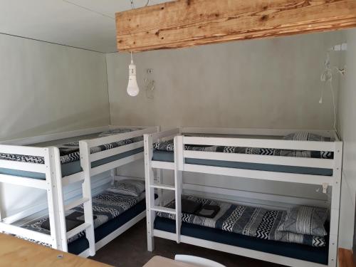 two white bunk beds in a room with a ceiling at Jūvgumegi in Mazirbe