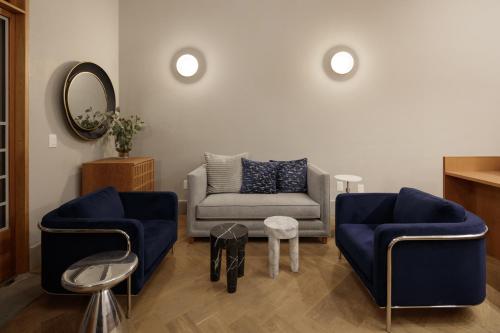 a living room with two blue chairs and a couch at Casa Bosque Eduviges in Guadalajara
