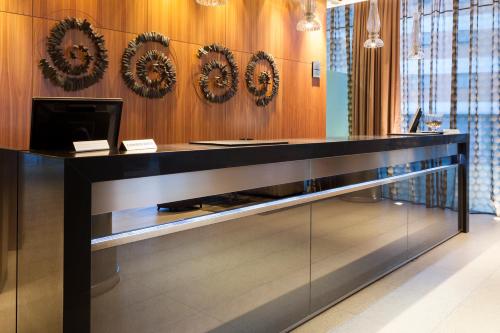 a reception desk in a lobby with mirrors on the wall at Porcel Torneo in Seville