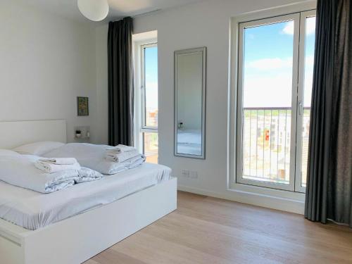 sypialnia z białym łóżkiem i dużym oknem w obiekcie ApartmentInCopenhagen Apartment 1453 w Kopenhadze