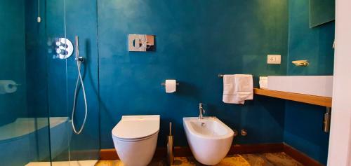 a blue bathroom with a toilet and a shower at Duomo Attic (rooms) in Ravello