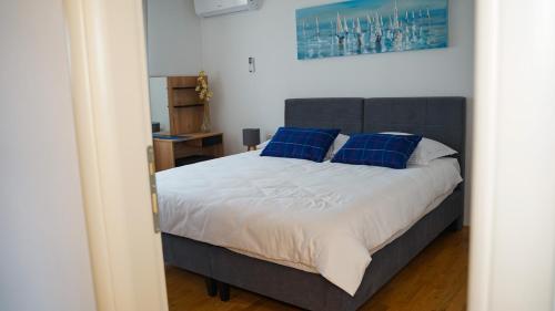 a bedroom with a large bed with blue pillows at Apartment Aria in Verunić
