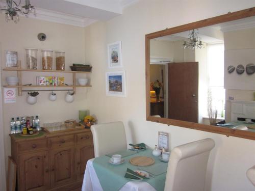 a dining room with a table and a mirror at The Old Town Bed and Breakfast in Hastings