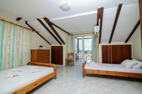 a bedroom with two beds and a balcony at SunBliss Studios & Apartments in Alykes